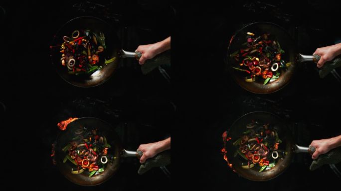 熟练的厨师在炒锅中翻炒蔬菜