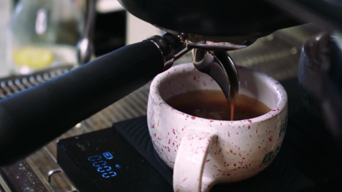 视频咖啡从机器流到杯子里。自制的热浓咖啡。现磨咖啡流。咖啡师在咖啡馆准备咖啡。