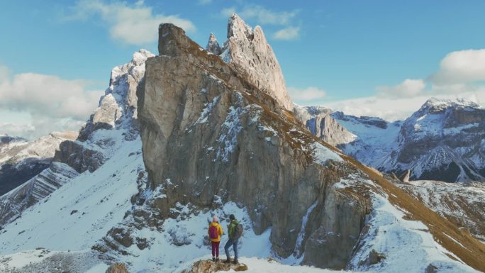 鸟瞰图的男人和女人徒步旅行的背景在塞塞达山在冬天