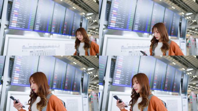 年轻的亚洲女子在国际机场用手机在航班信息板上查询航班