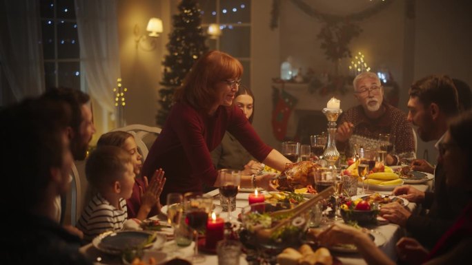 带着孩子和朋友的家庭欢聚一堂，享用美味的烤火鸡的圣诞晚餐。家里充满了节日的气氛，奶奶把主菜端上桌