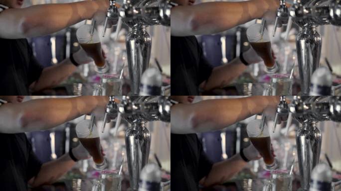 在啤酒咖啡馆里，酒保把精酿啤酒倒进玻璃杯里。