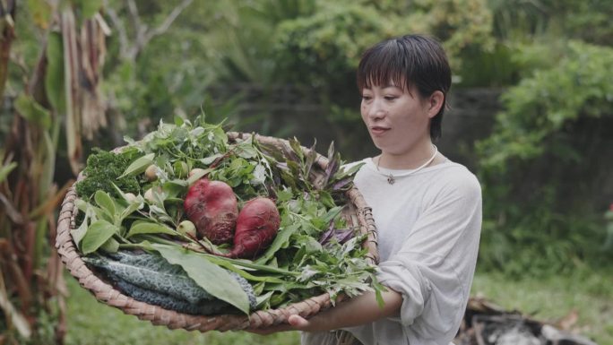 一名日本妇女拿着菜园里的新鲜作物