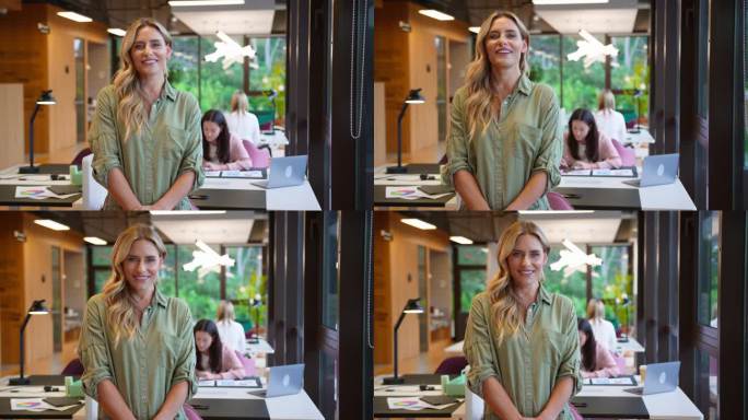 在现代的开放式办公室里，成熟的女商人站在办公桌前休息时微笑的肖像——慢镜头拍摄