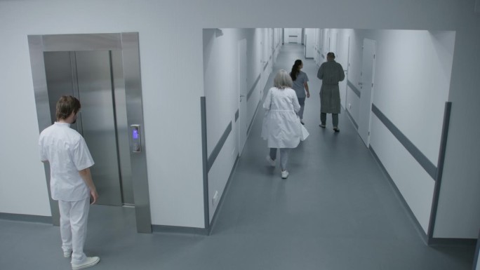 繁忙的医院走廊:男医生走进电梯
