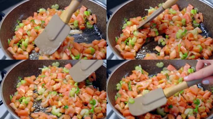 剁碎新鲜的红番茄、大蒜、洋葱和青芹菜，在锅中炖煮，人用锅铲搅拌蔬菜，在家里准备美味健康的食物