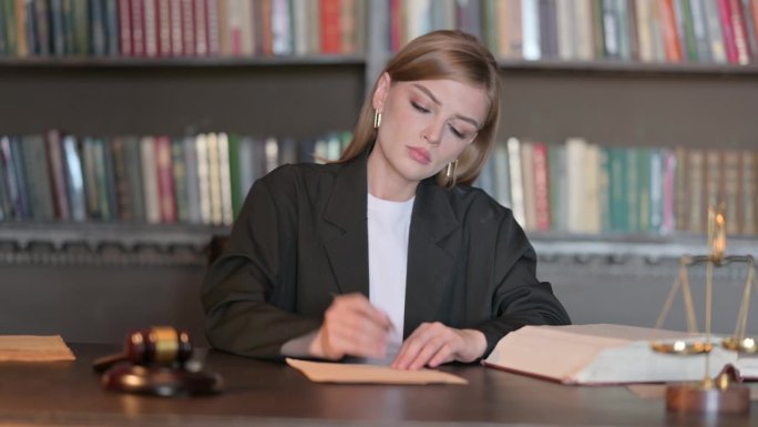 年轻女律师在办公室写法律文书