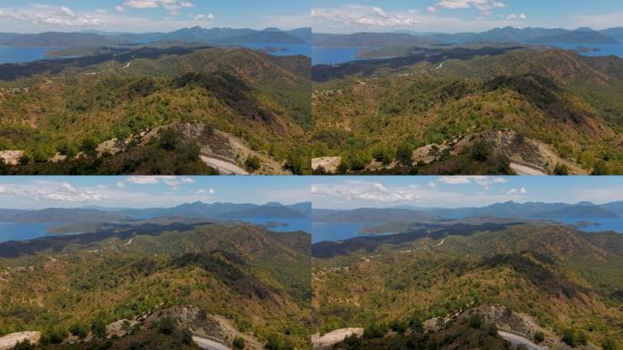 空中无人机拍摄的马尔马里斯半岛美丽的风景，山脉和丘陵，绿色的树林和弯弯曲曲的道路。环绕着爱琴海和地中