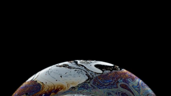 泡泡充满了彩虹墨水的漩涡图案，就像一个行星抽象的背景