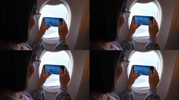 一名年轻女子正在拍飞机窗外的风景