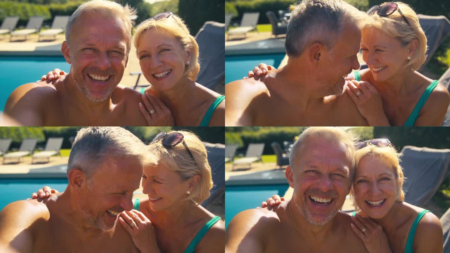 度假的老夫妇在游泳池边自拍放松的POV镜头