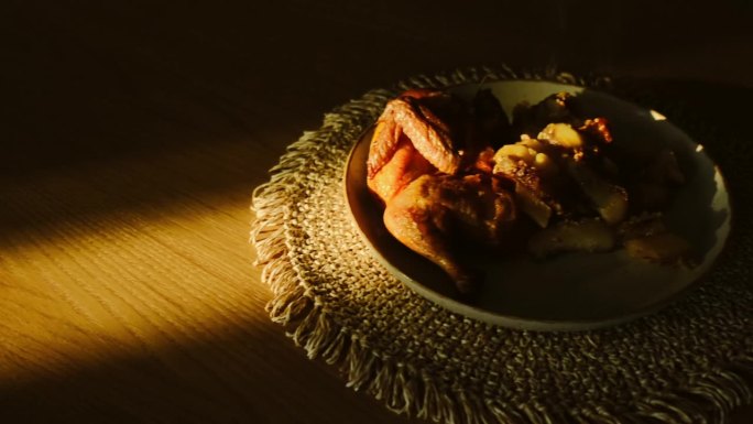 烤鸡在木桌上冒着热气。金黄的烤鸡翅皮配蔬菜。美味的家常菜，电影般的场景