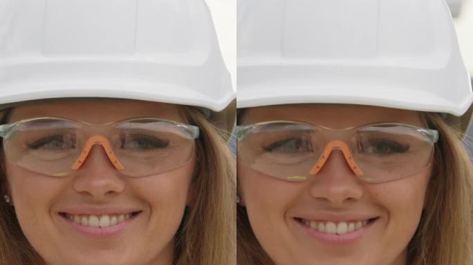 一个女工程师的肖像，微笑着看着镜头。环境创新:设计师专注于创造一个风力涡轮机为子孙后代提供绿色电力的