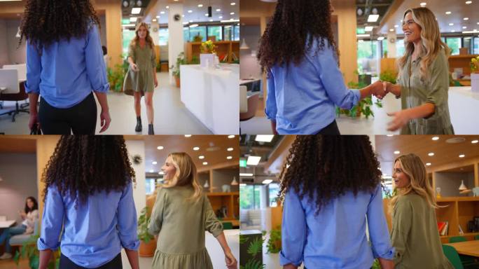 两个女商人在现代的开放式办公室里会面并握手——慢镜头