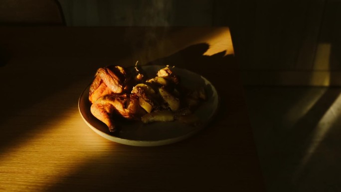 烤鸡在木桌上冒着热气。金黄的烤鸡翅皮配蔬菜。美味的自制食物，电影般的场景
