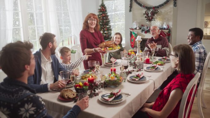 家人、孩子、朋友和年轻夫妇聚在家里吃圣诞大餐。不同的人享受美味的火鸡大餐，分享温馨的对话。温馨节日庆