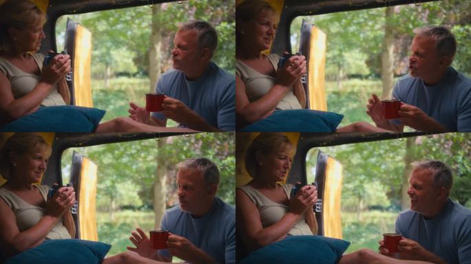 老年退休夫妇在乡村露营，一起在房车里放松地喝咖啡的特写