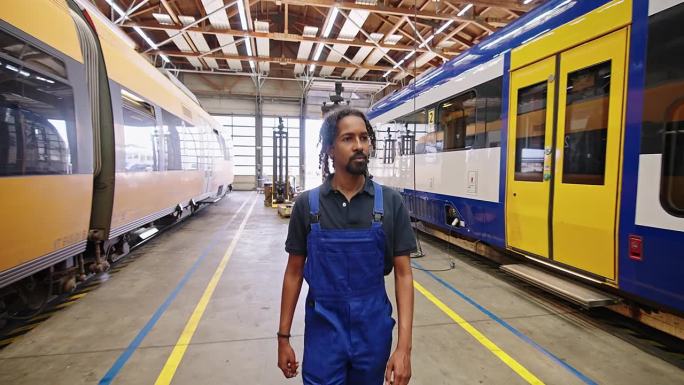 身穿制服的非洲工程师在铁路车间行走