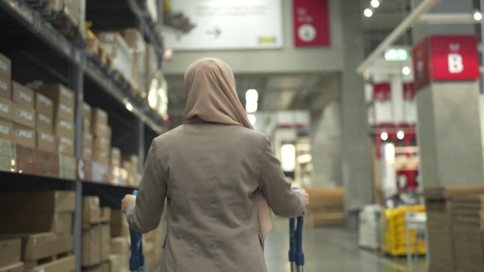 4K穆斯林妇女在仓库推着手推车