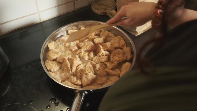 从肩膀上看，在平底锅里烹饪素食TVP纹理植物蛋白，慢动作4K