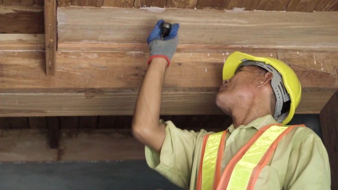 亚洲资深木匠在家里补天花板的缝隙。