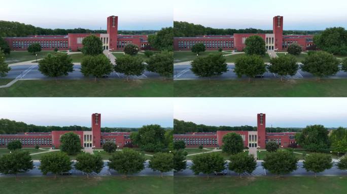 日落时分的美国高中。卡车航拍的外部前门的照片。大型砖砌教育大楼。