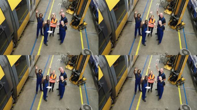 火车维修工程师站在一起挥手的高角度照片