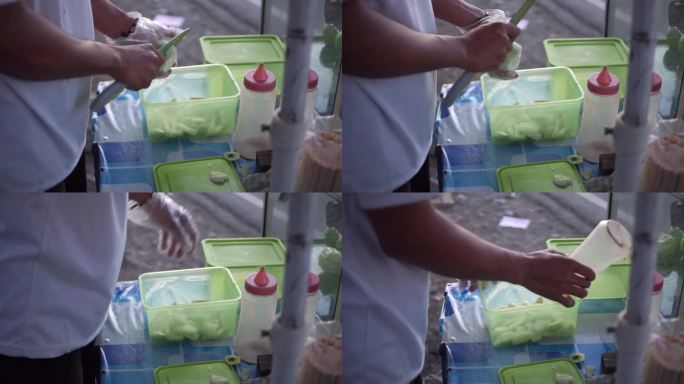 2023年9月20日，印度尼西亚明库鲁:一名卖水果沙拉的男子正在切水果并包装给买家
