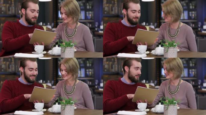 微笑的情侣看菜单选餐