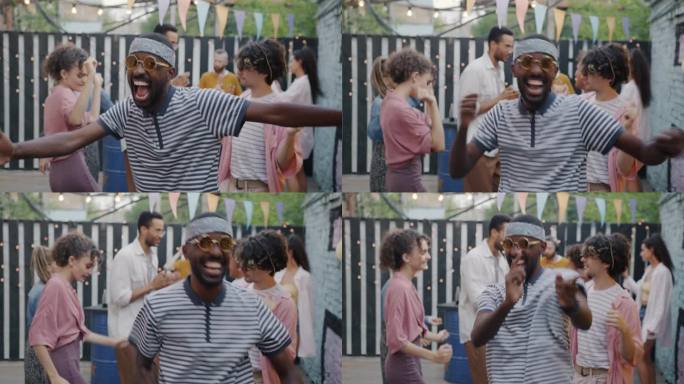 悲伤的非洲裔美国人站着跳舞，在咖啡馆的露天派对上玩得很开心