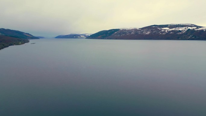 鸟瞰雄伟的尼斯湖全景。水面周围被雪覆盖的小山。英国苏格兰