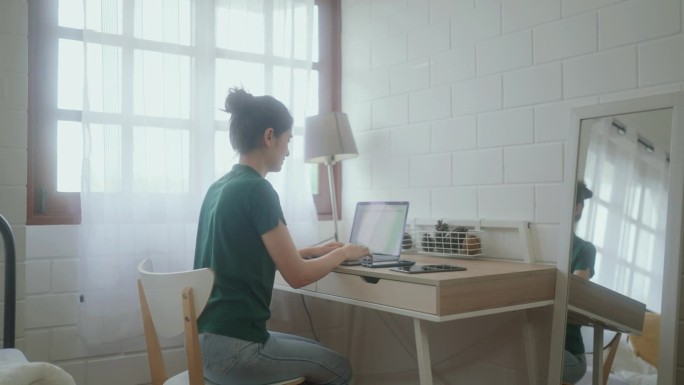 现代自由职业女性在家庭办公室使用笔记本电脑，建立一个成功的在线企业。