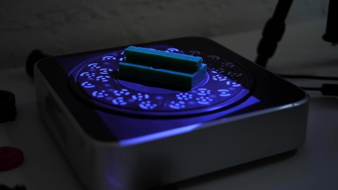 一个正在工作的现代3D扫描仪从一个塑料物体上读取数据。紫外线