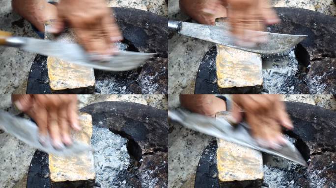 一位老人用一块湿石头磨刀。要使刀锋利，传统的泰国方法是在磨刀石上来回摩擦。手洗刀。