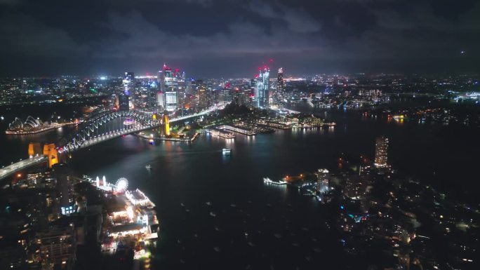 4K鸟瞰图实时拍摄悉尼海港大桥，环形码头，歌剧院和悉尼海港办公室和豪华大楼群在夜间的画面