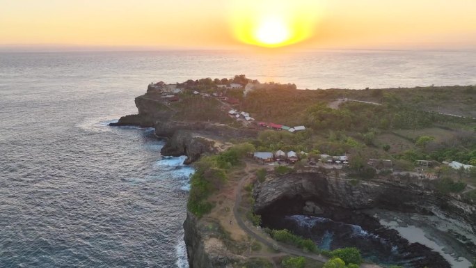 破碎海滩的移动海浪日落场景是巴厘岛努沙佩尼达岛最著名的观光景点之一。这是岩石中形成的一个神奇的马蹄形