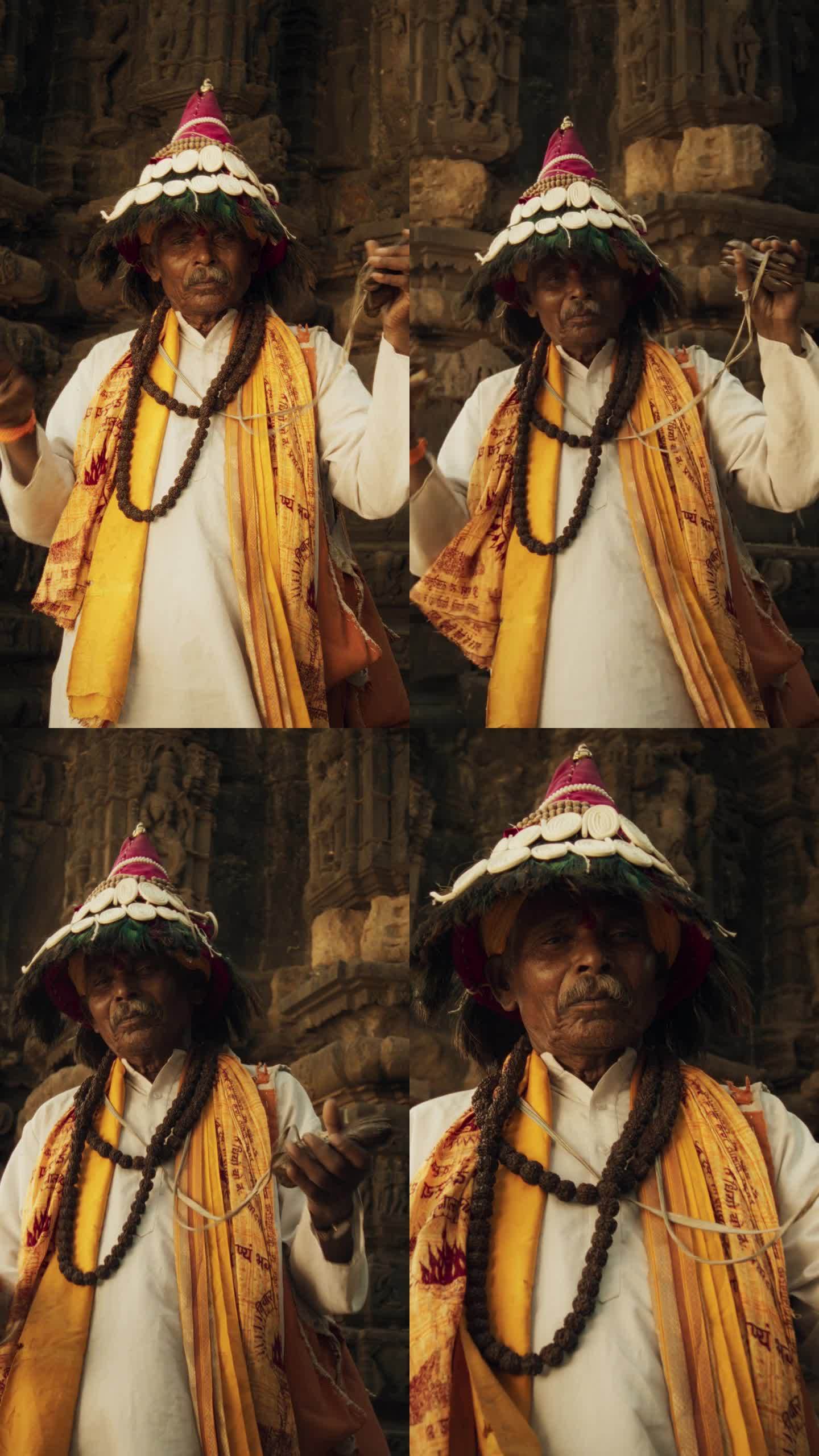 竖屏:一个穿着传统服装的印度老人在古印度寺庙里演奏乐器和诵经的画像。节日老人，传承传统文化遗产