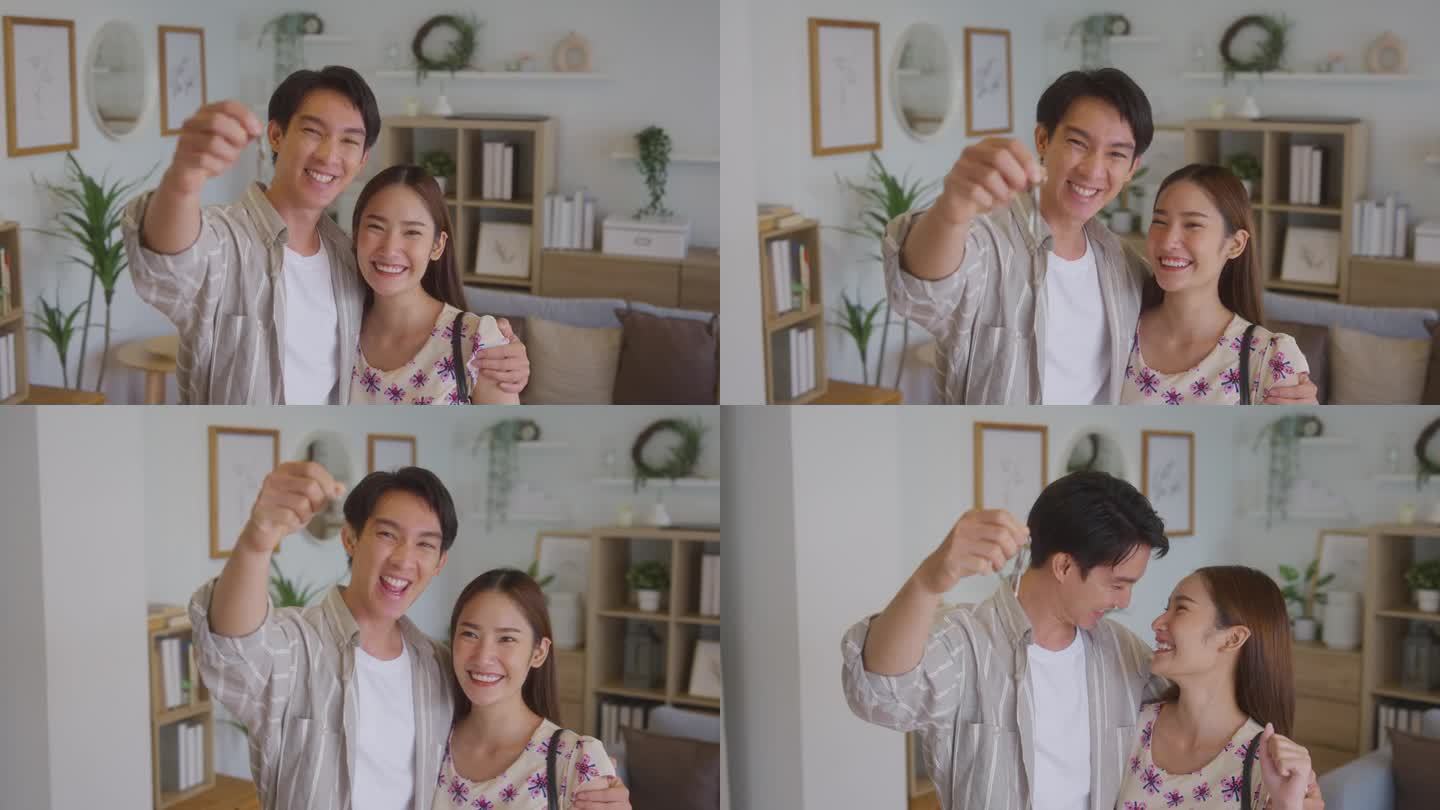 幸福的年轻亚洲夫妇微笑着，展示他们共同购买的新房子的钥匙，准备结婚，组建家庭。