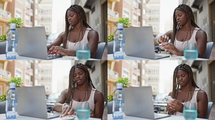 非裔美国妇女在咖啡店露台上用笔记本电脑和智能手机看手表