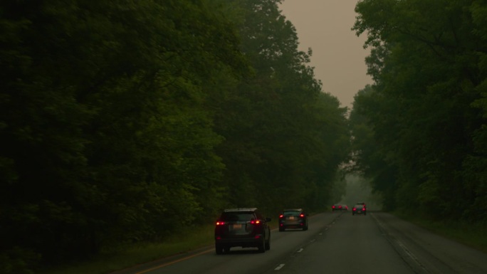 雾蒙蒙的路上的高峰时间。汽车在烟雾下行驶到地平线上，马里兰州。司机车牌摄像头运动