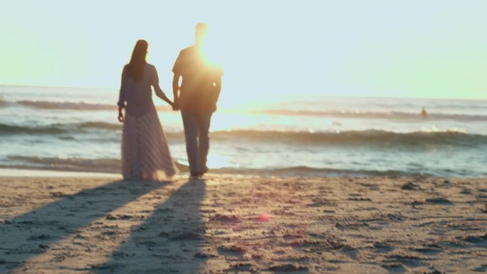 夕阳西下，男人和女人手牵着手在沙滩上散步，在夏天约会，度假和情侣。爱情，日出和大自然中的人们在泰国度