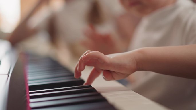 孩子胖乎乎的手指按下钢琴键学习作曲