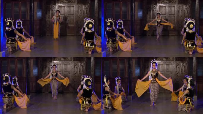 一群印度尼西亚舞者在舞台上的蓝色灯光下一起跳舞