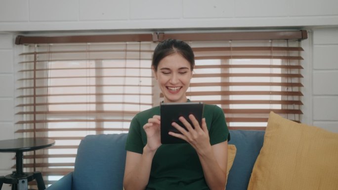 幸福与联系:舒适沙发上使用平板电脑的多元女性——拥抱现代科技的乐趣。