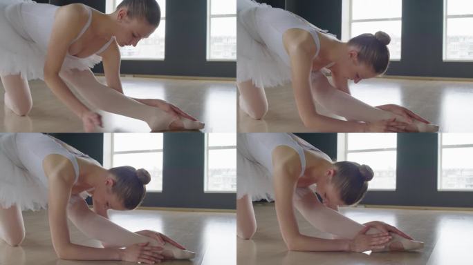 芭蕾舞演员把她的身体拉到腿上