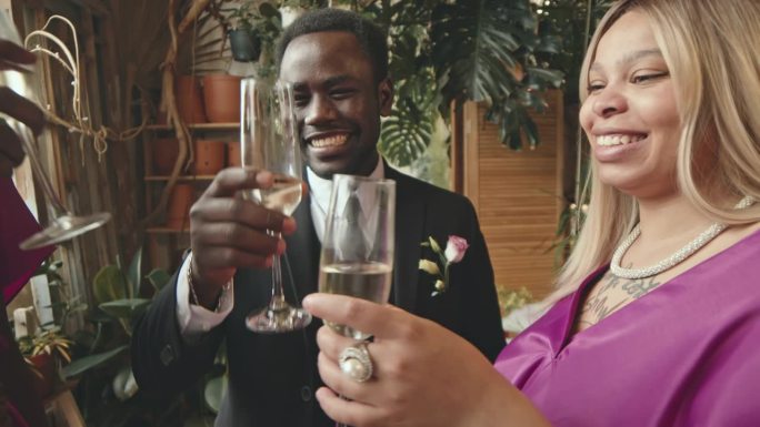 新婚丈夫和宾客用香槟酒杯敬酒