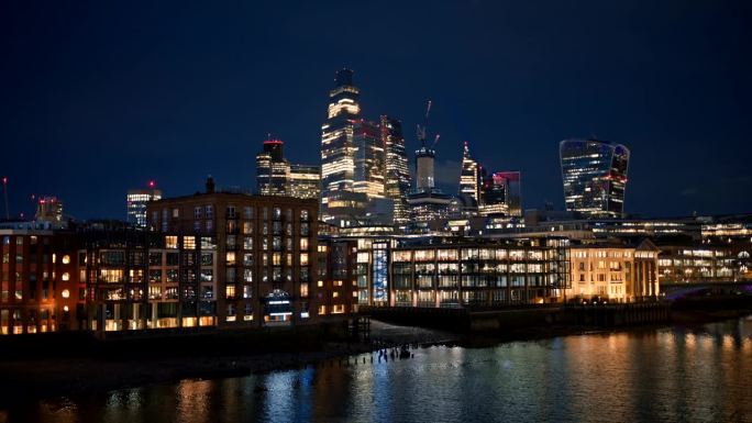 伦敦市中心的夜景，英国。在市区的摩天大楼和其他建筑物，泰晤士河，大量的照明