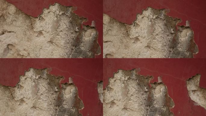在一座古老的岩石房子里，把酒红色墙壁上的灰泥刮掉。老化的概念。纹理背景的文字，字幕或照片。Copys