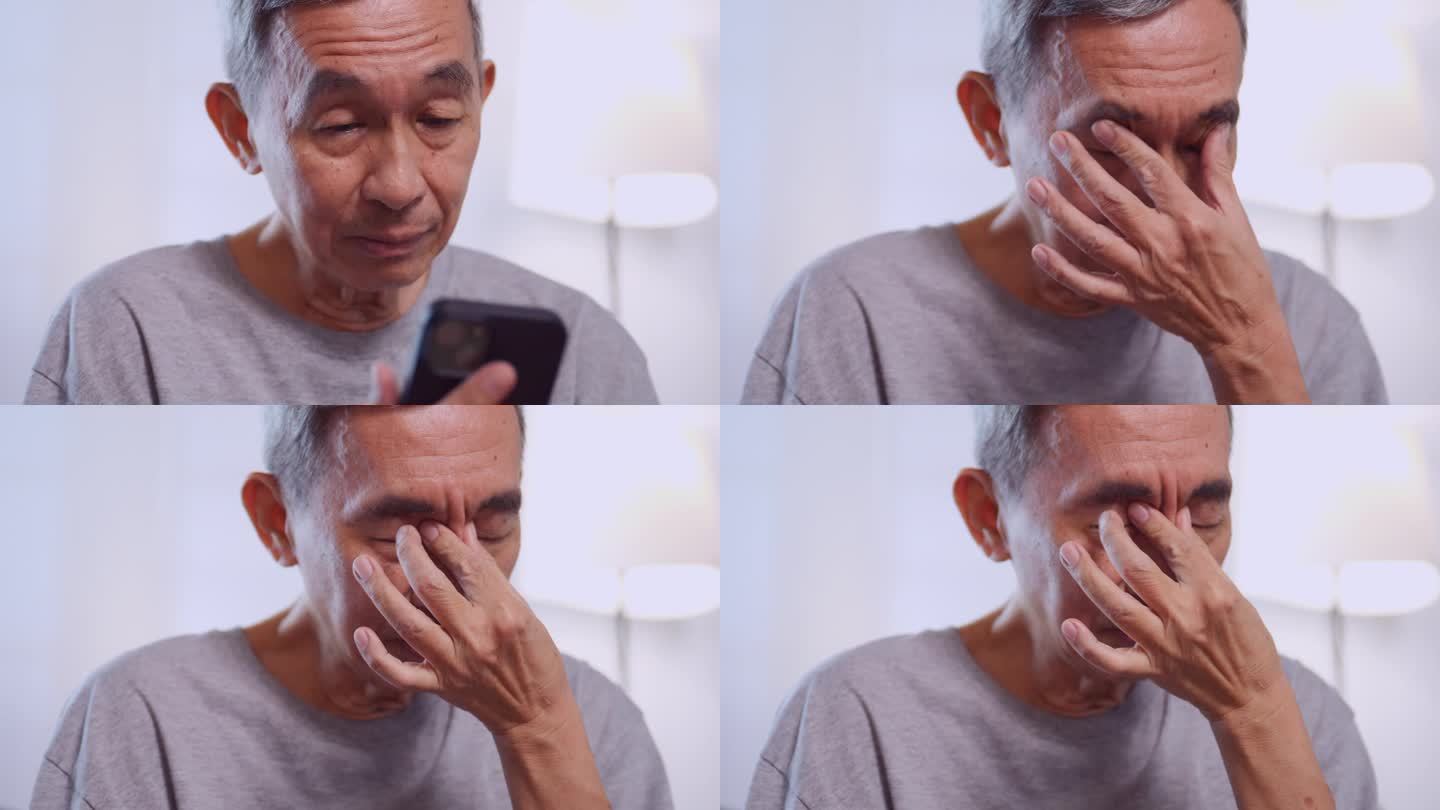一位亚洲老人因长时间盯着手机而视力模糊。