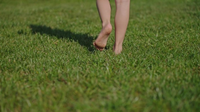 小孩赤脚走在草地上的影子特写超级慢动作